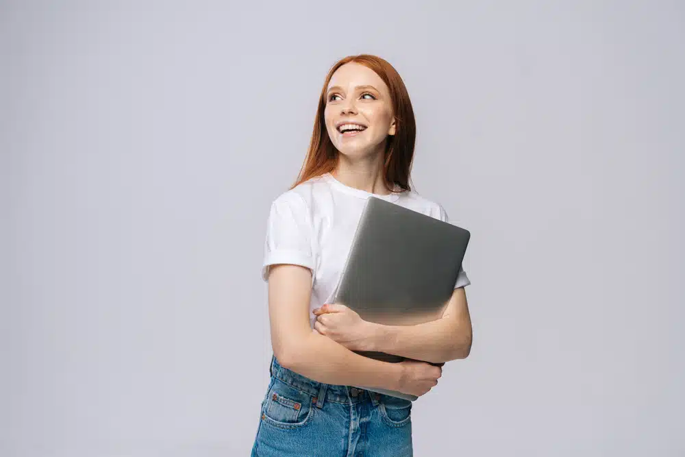 a woman student holding a laptop
