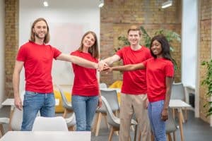 Team of young volunteers in red shirts