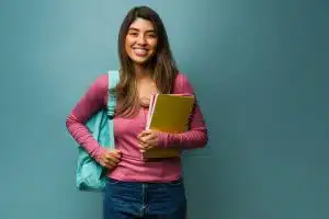 woman wearing a backpack while carrying books