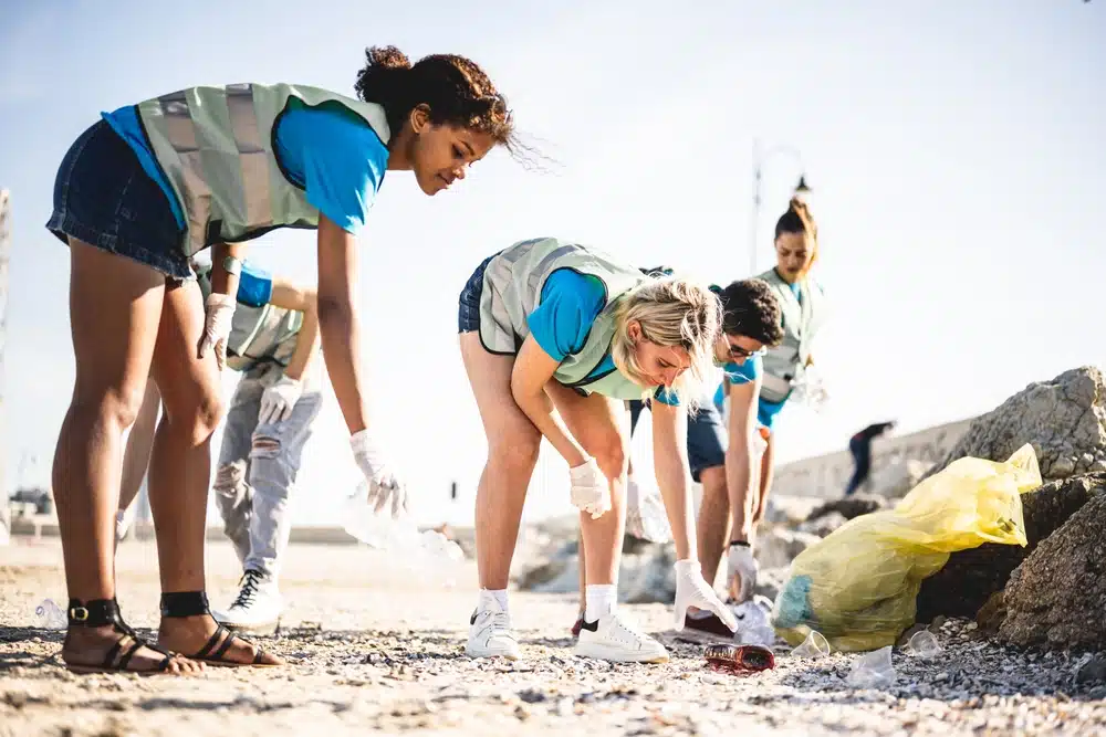 Students cleaning up the beach, volunteers collecting the waste on the coast line
