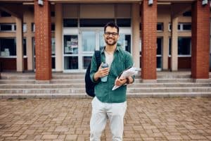 male student standing in front of university