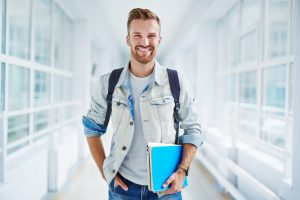 guy with book and touchpad looking at camera