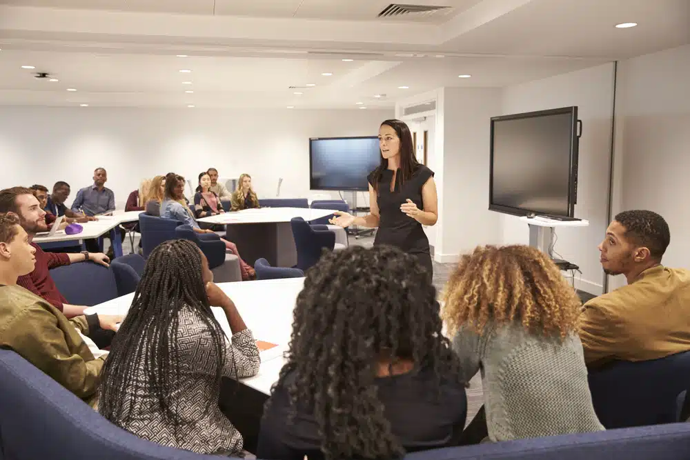 Female teacher addressing students in a classroom