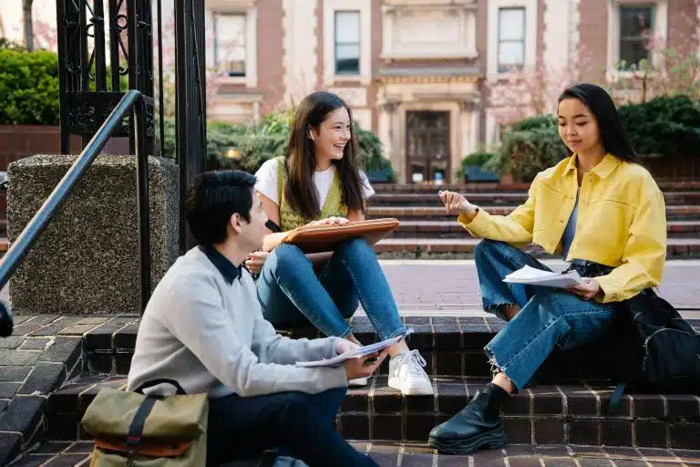 A group of students chatting outdoors on the steps