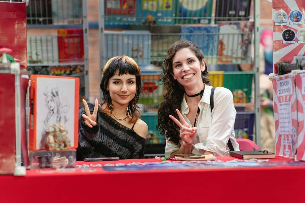 Two students posing for a shot in their anime club booth at a club fair
