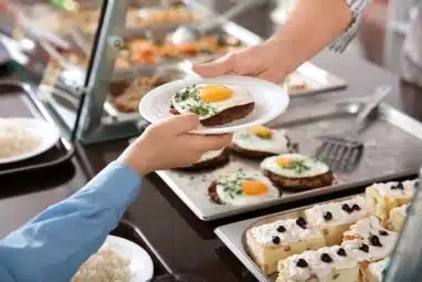 Woman giving plate with healthy food to boy in school canteen, closeup