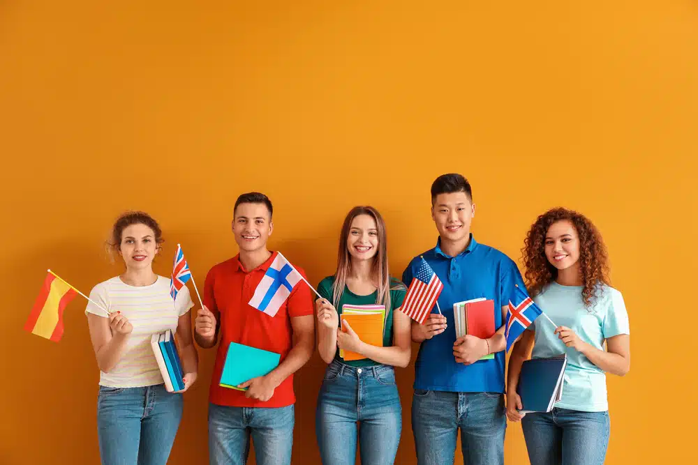 Young students of language school on color background