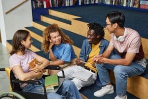 Diverse group of young people chatting in college library