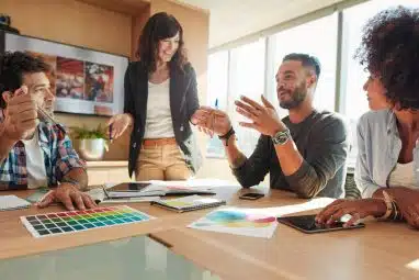 A group of graduates engaged in a collaborative discussion, representing how schools with the best alumni networks create lasting professional connections and career opportunities.
