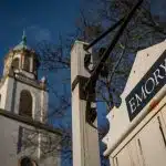 A close-up of the Emory University entrance gate and bell tower under a clear blue sky, representing the Emory application deadline and the university’s historic campus atmosphere.
