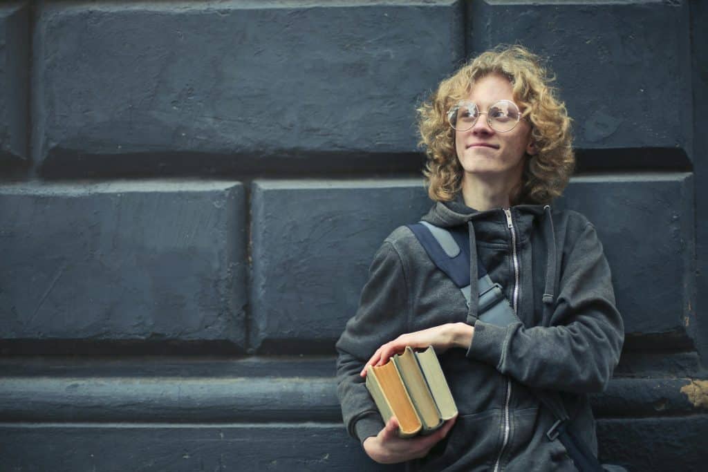 student in blue holding books