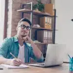 a young man thinking what to write in his essay to apply for business summer programs for high school students
