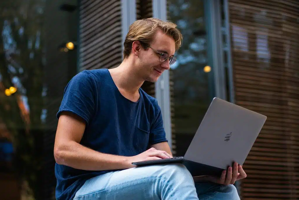 A high school student studies physics on a laptop, exploring summer programs for high school students.