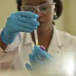 Student conducting a lab experiment with test tubes, representing research opportunities at the best colleges for bioengineering