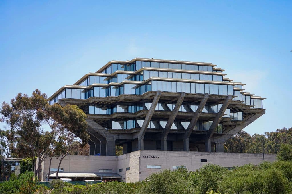 Exterior view of Geisel Library at UC San Diego with trees and blue sky, representing UCSD application deadline.