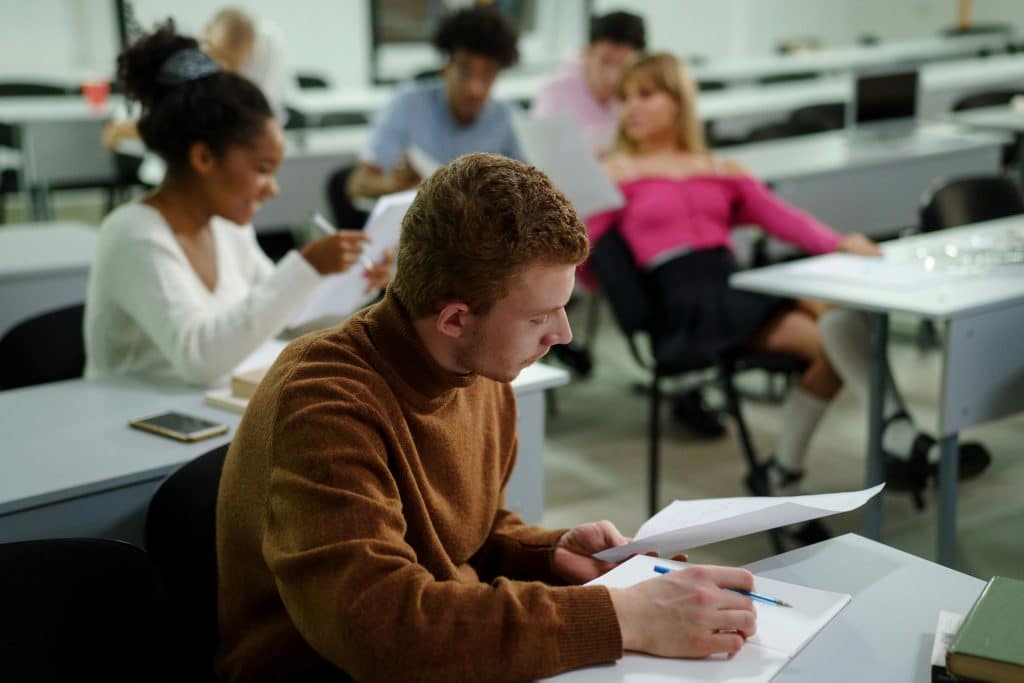 Student in brown sweatshirt sitting down studying SAT Vocabulary words