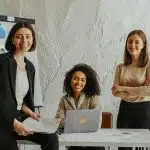 Students collaborating on a business project with charts and a laptop, representing programs at the best colleges for business