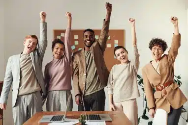 Group of interns raising their fist in the air cheering