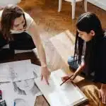 High schools students sat on the floor working on some sketches
