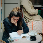 female student studying from a thick book