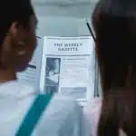 Two students examining the rough outline of a newspaper