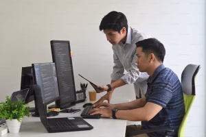 two programmers working on a computer