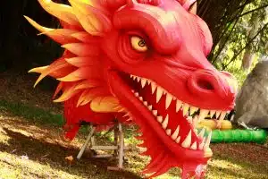 a red dragon statue on top of a green field