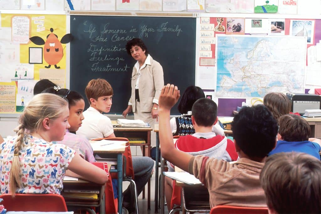 woman standing in front of children in classroom
