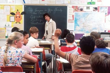 woman standing in front of children in classroom