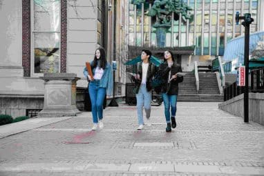 3 college students walking on campus, exploring idea of safety schools