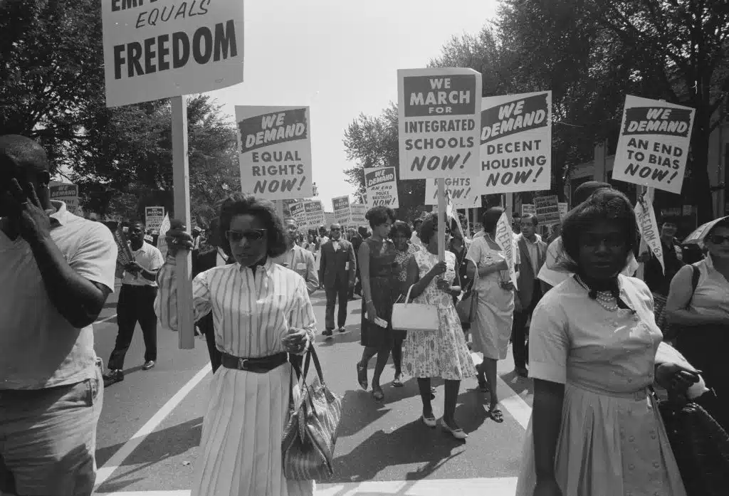 Civil Rights demonstrators holding signs for equal rights, integrated schools, and fair housing, an image often studied in AP African American Studies to highlight the fight for justice during the 1960s