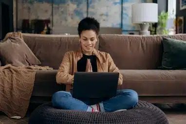 student in brown jacket waiting looking at a laptop for the pomona college application deadline