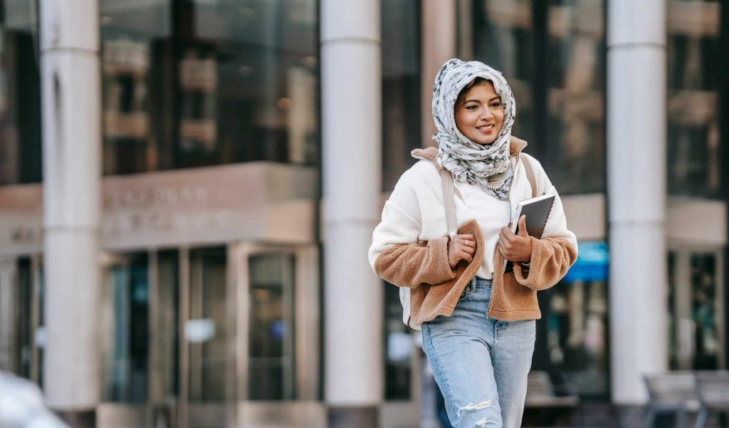 woman walking in campus checking when do barnard decisions come out