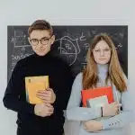 Two students holding books for the HCSSiM