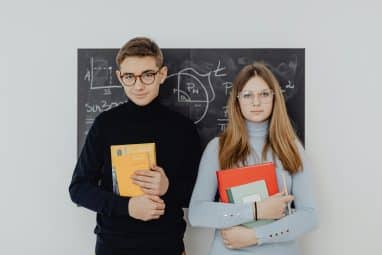 Two students holding books for the HCSSiM