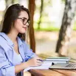 A student studies outdoors on her laptop while preparing for the National Technology Honor Society.