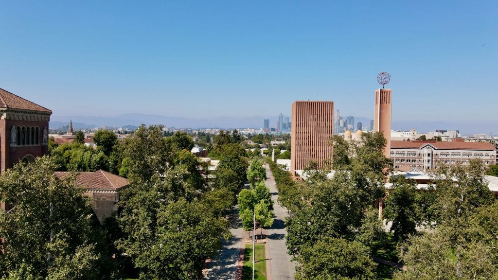 A scenic view of the USC campus with tree-lined walkways and iconic buildings under a clear sky, representing key details about the USC application deadline.