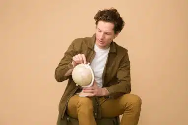 a student holding a tiny globe looking for the best international universities for American students