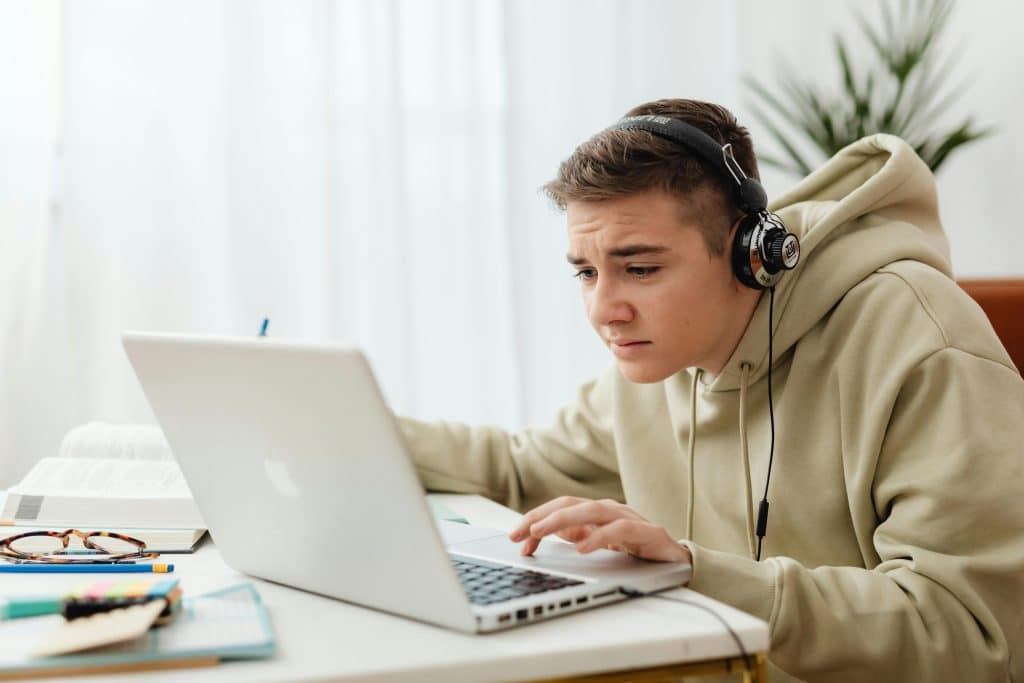 A student studies on a laptop while reviewing Case Western SAT requirements.