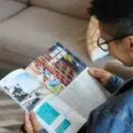 A person reading a magazine with articles on education and career growth, symbolizing the in-depth analysis and rankings featured in Money Magazine Best Colleges.