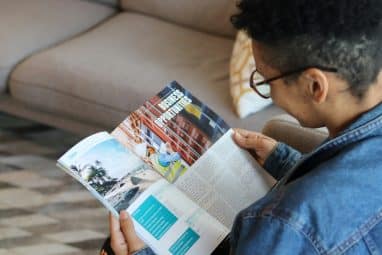 A person reading a magazine with articles on education and career growth, symbolizing the in-depth analysis and rankings featured in Money Magazine Best Colleges.