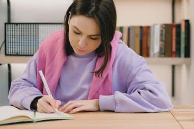 A student writes in a notebook while studying for Rice University SAT requirements.