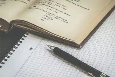 A close-up shot of a notebook and a book with a math equation that students use to meet the Notre Dame SAT requirements.