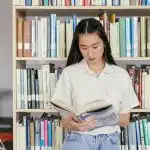 A student reading in a university library, representing the academic preparation needed to meet Wake Forest SAT requirements.