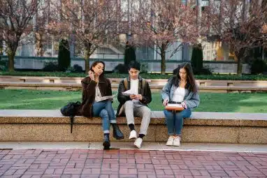 students sitting down in a bench inside ivy league colleges