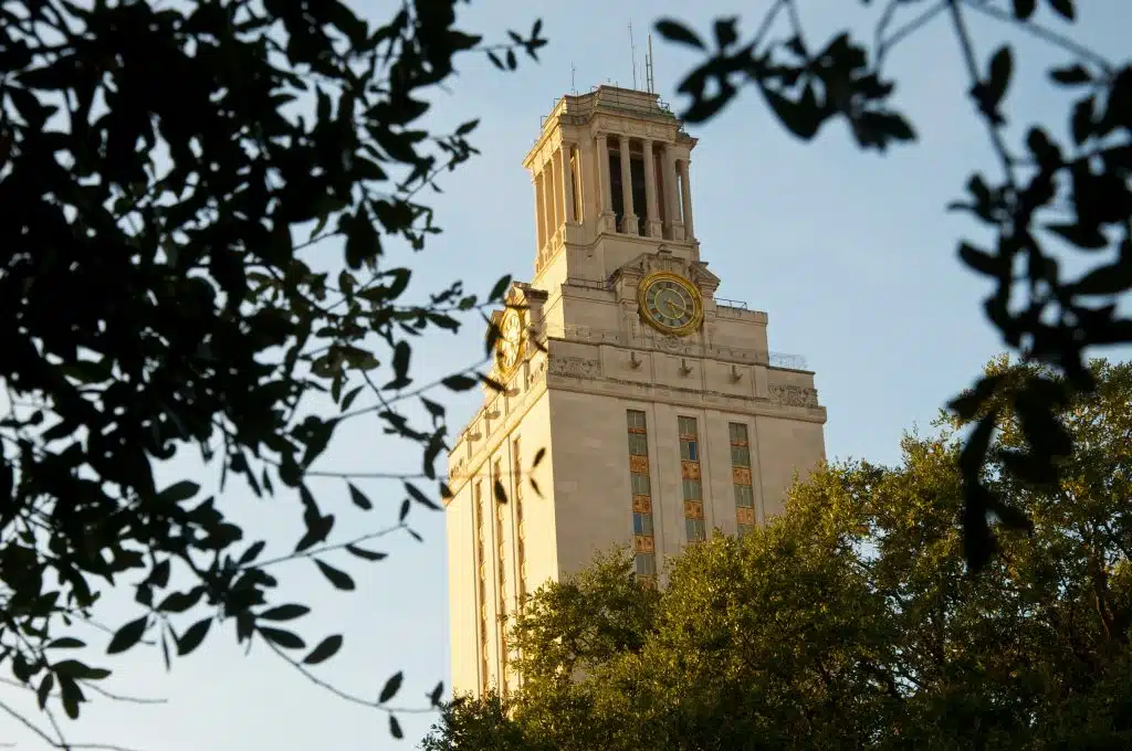The University of Texas Tower framed by trees at sunset, illustrating information about University of Texas free tuition.