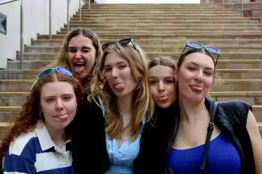 A group of female friends out and about applying to summer internships for high school students.