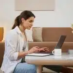 student infront of a laptop looking for good economics research topics