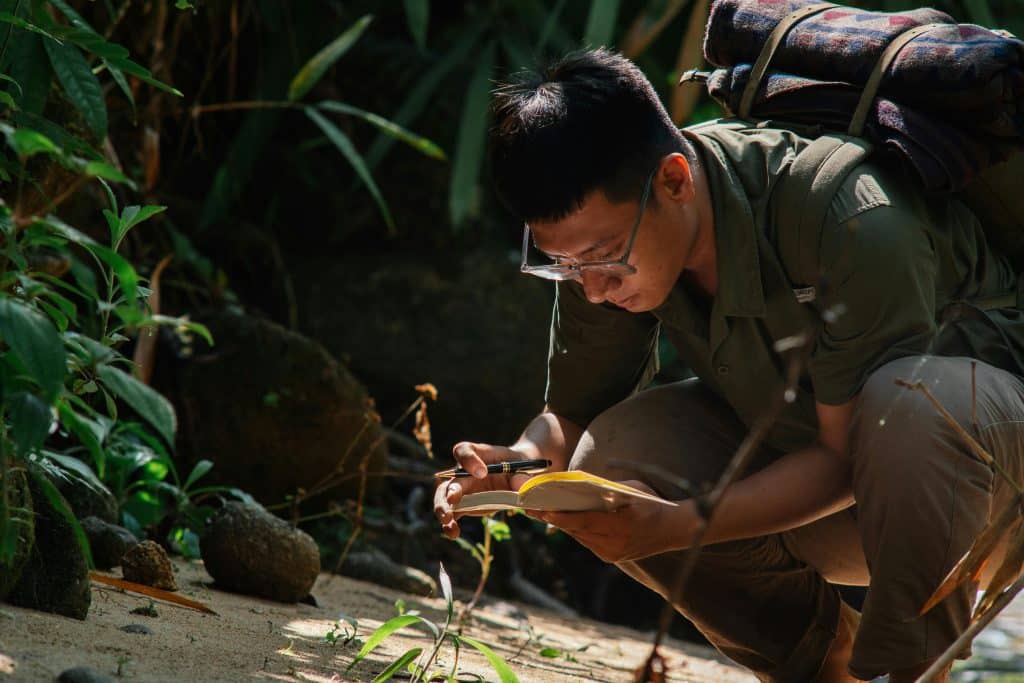 student studying plants as part of the environmental science summer internships he is in