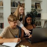 students looking at a laptop for the best physics internships for high school students